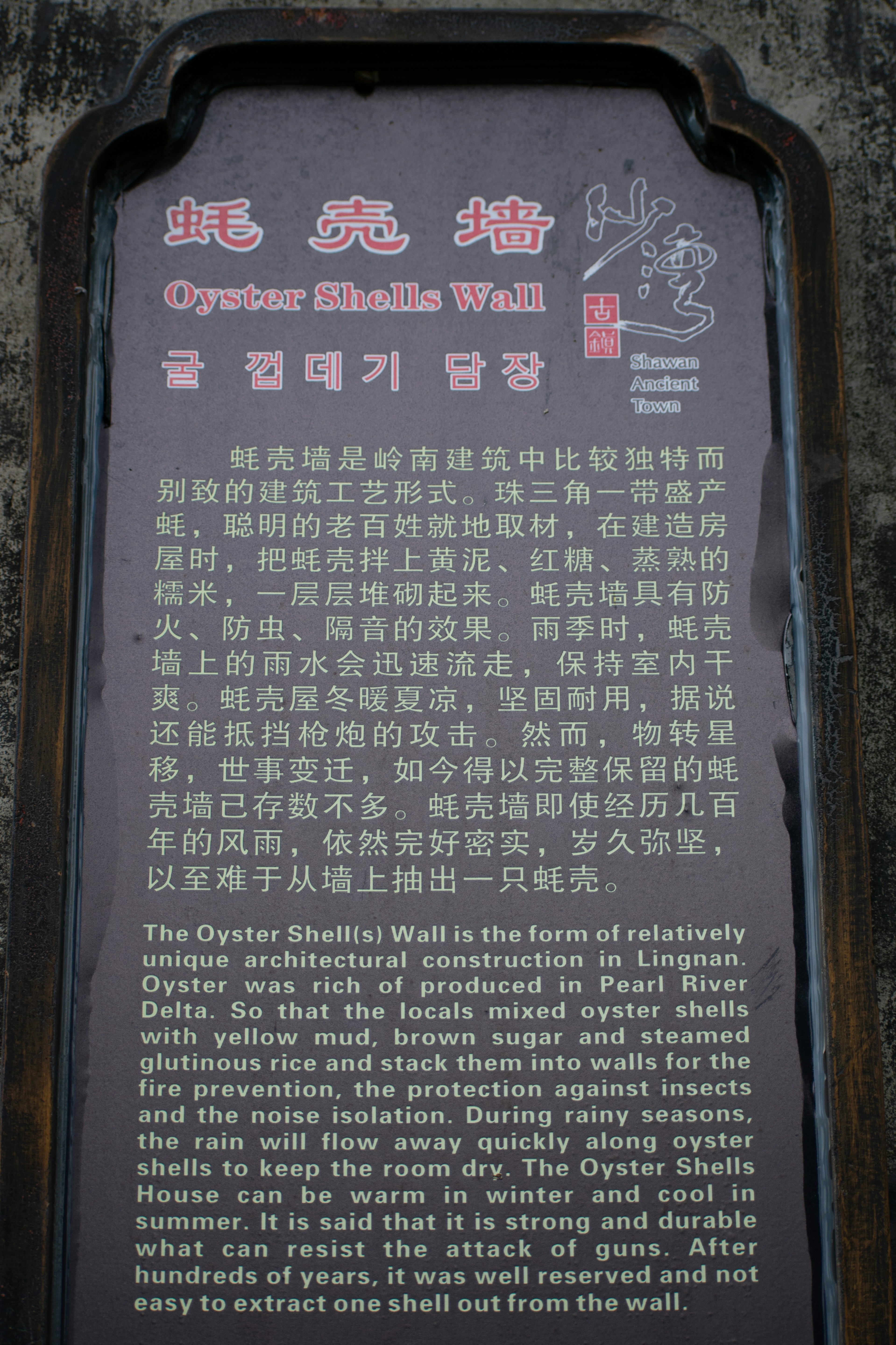 A sign on the side of a building with writing on it